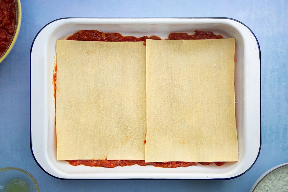 Overhead shot of lasagne sheets in a lasagne dish