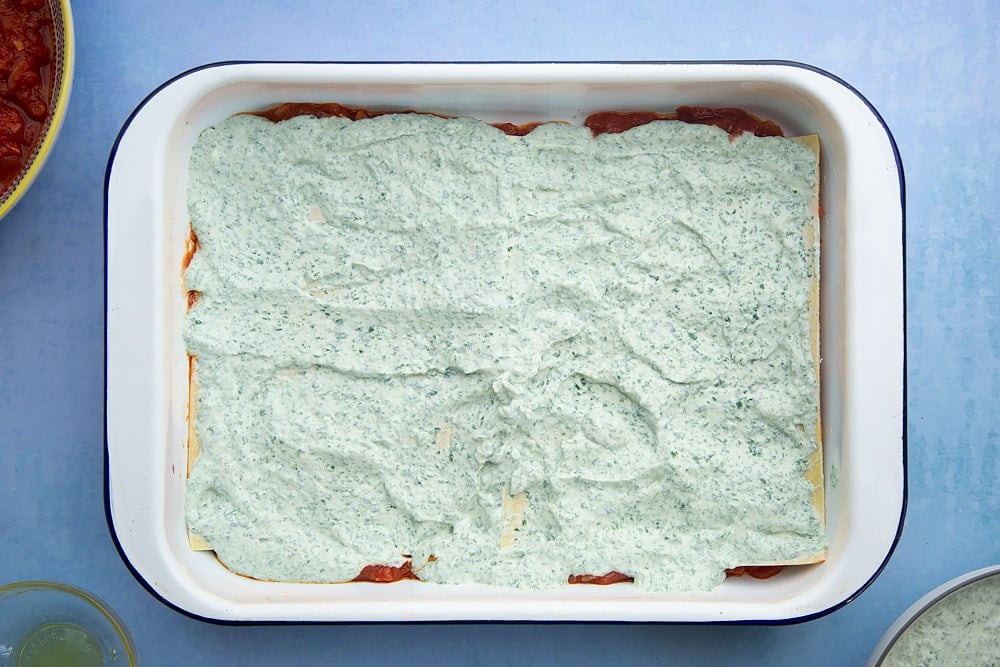 Overhead shot of spinach and ricotta layer in a lasagne dish