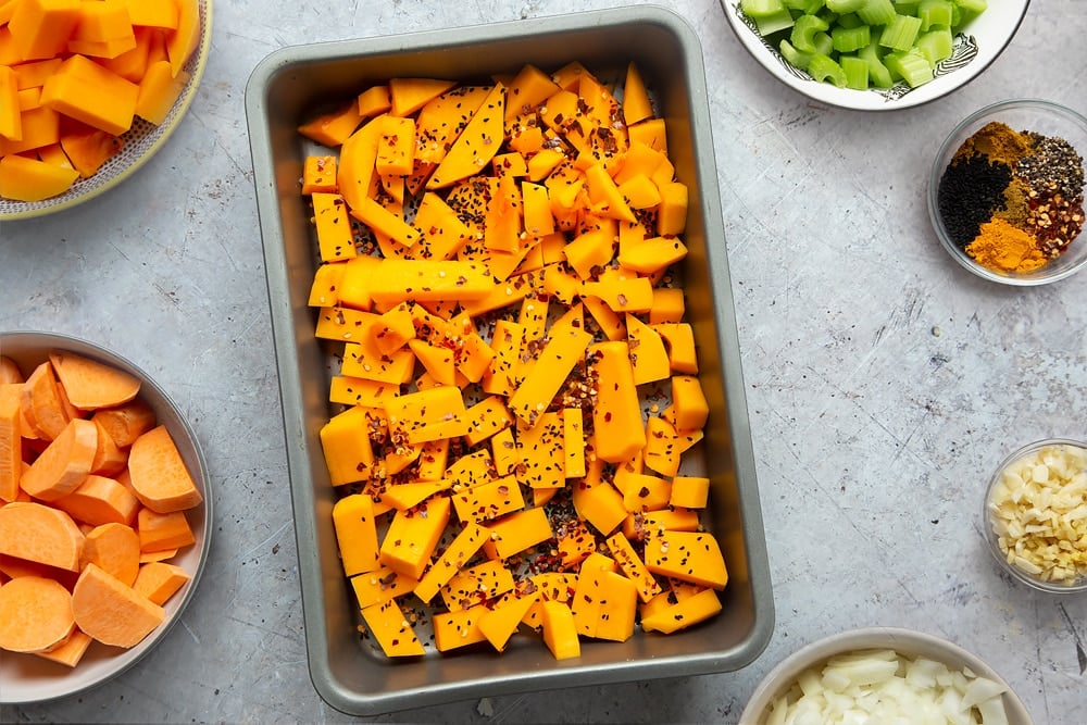 Sprinkling onions, chilli flakes and salt onto the butternut squash.