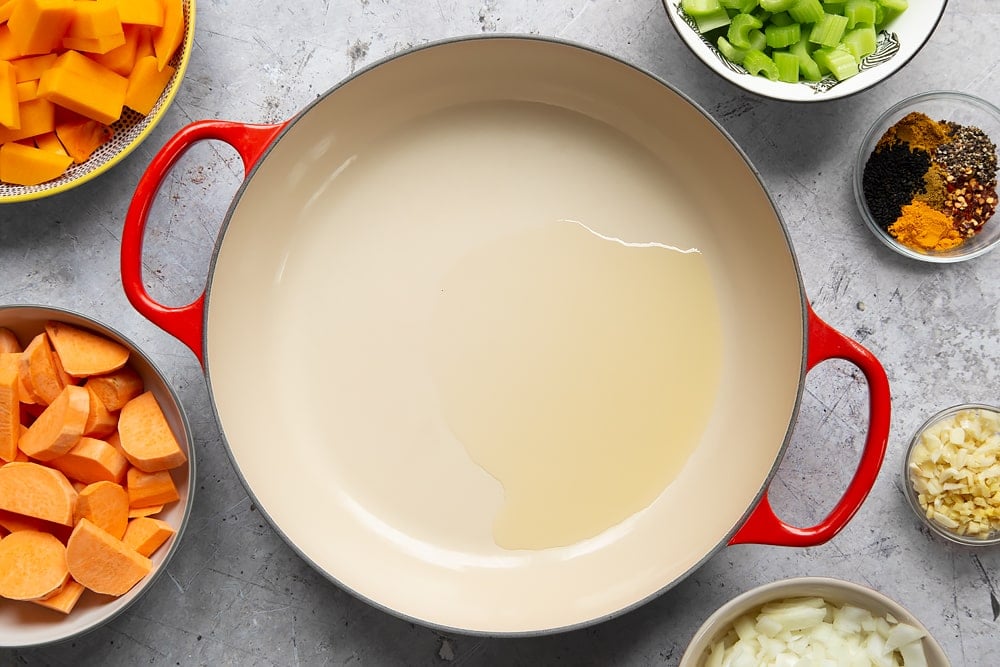 Start the butternut squash and chickpea curry recipe by heating oil in a large pan. 