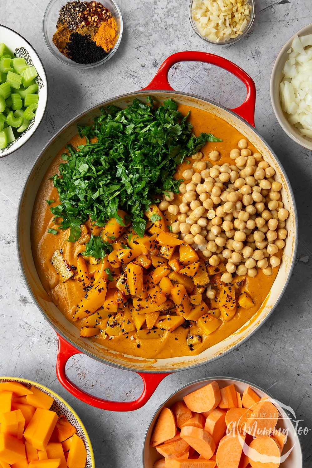 Adding the final ingredients to the butternut squash and chickpea curry.