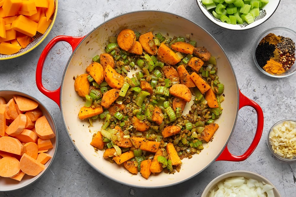 Cooking the butternut squash and chickpea curry ingredients in a pan while stirring regularly.  