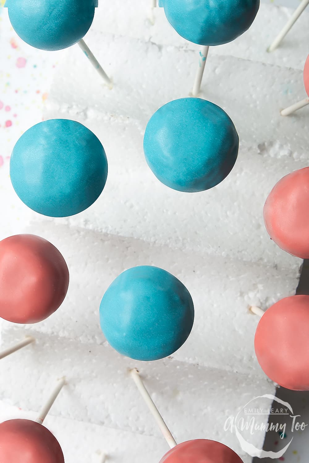 Blue and pink cake pops drying, ready to make a cake pop bouquet.