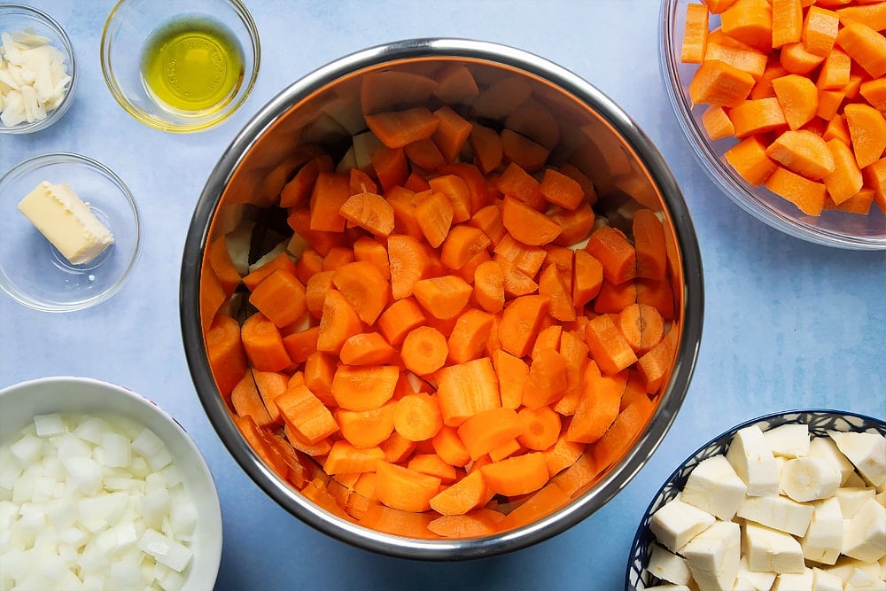 Adding the carrots into the pan which has already been filled with parsnips.