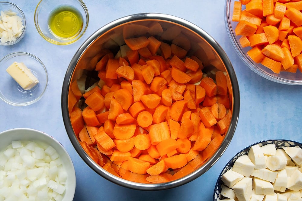 Adding the carrots into the pan which has already been filled with parsnips. 