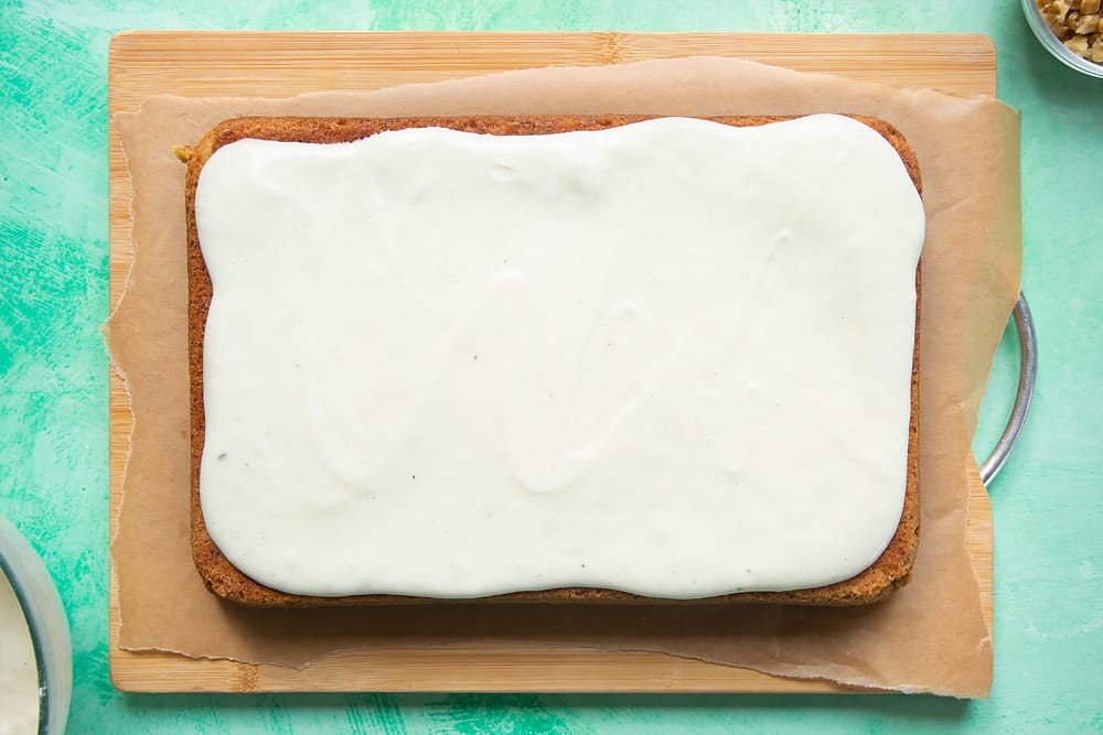 Spreading the creamy frosting over the carrot cake tray bake