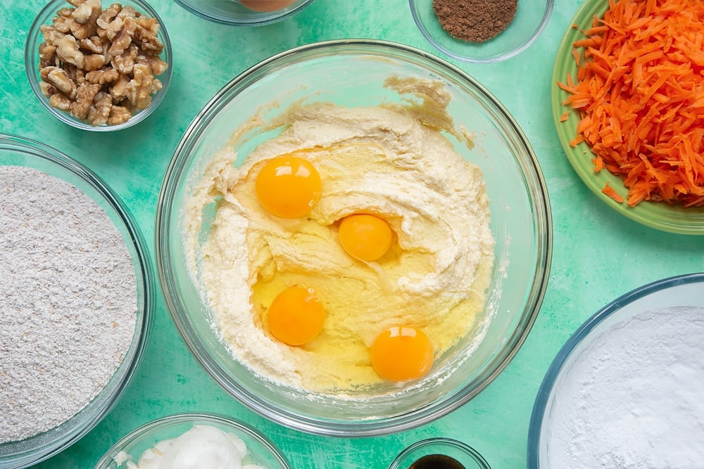 Adding the eggs to the carrot cake tray bake mixture. 