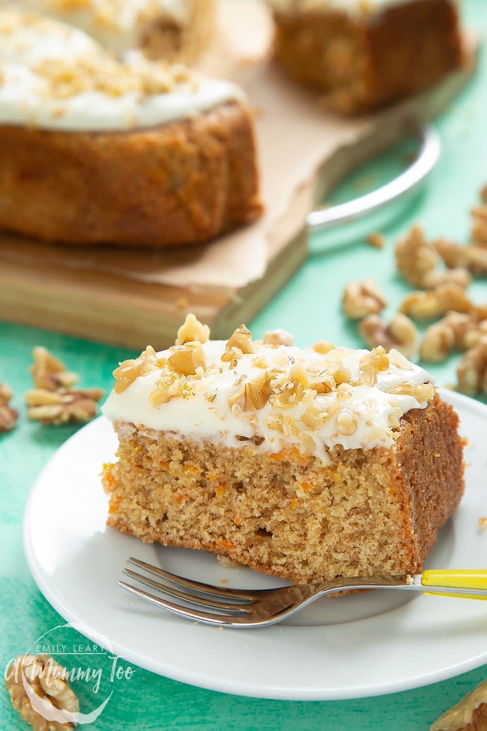 A sliced serving of the carrot cake tray bake on a plate with a desert fork. 