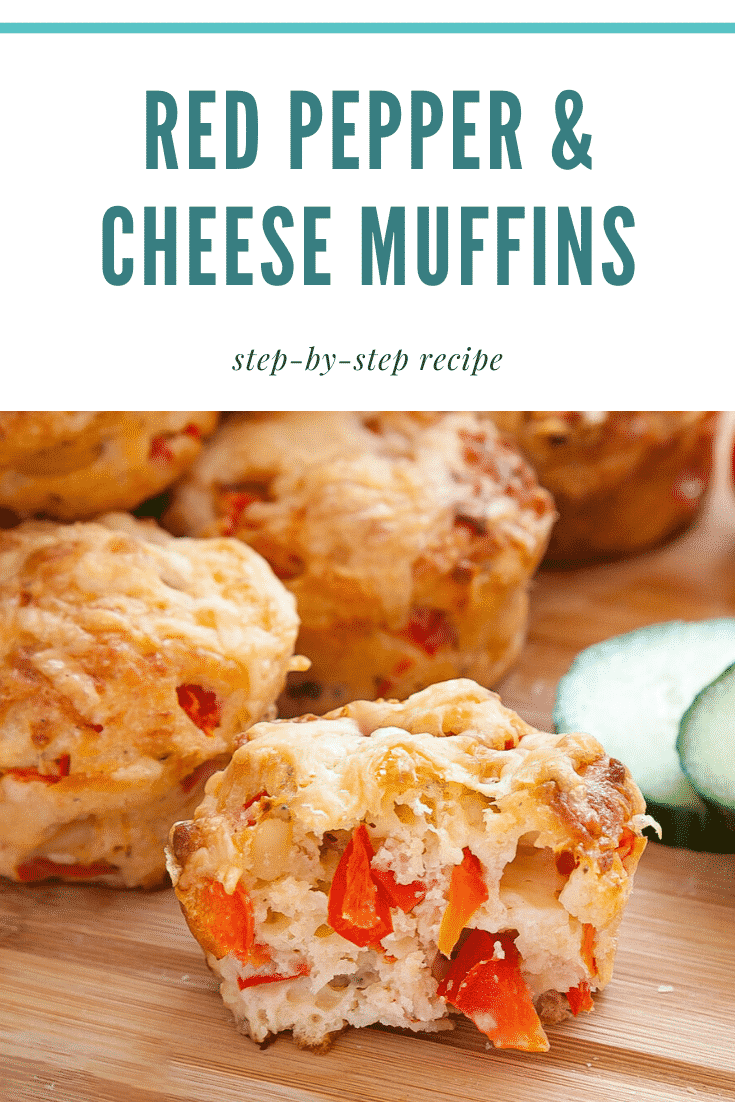 A cut open cheese and red pepper muffins on a wooden board. In the background there's some additional cheese and red pepper muffins. At the top of the image there's some text describing it for Pinterest.