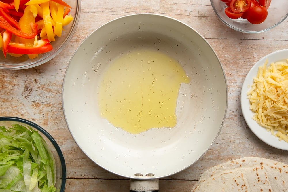 To start our serving of Mild chicken fajitas for kids we need to fry oil in a pan.