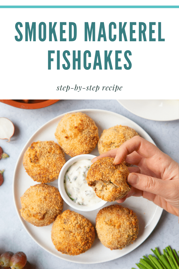 The inside of a mackerel fishcake held over a white plate filled with additional mackerel fish cakes. At the top of the image some teal text describes the image for Pinterest.