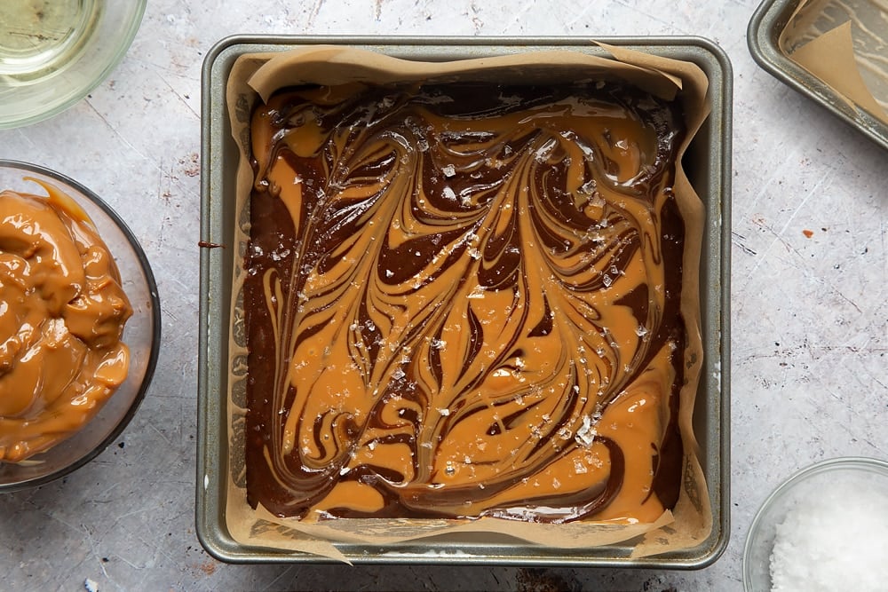 Sea salt sprinkled on the top of the  gooey salted caramel brownies mixture