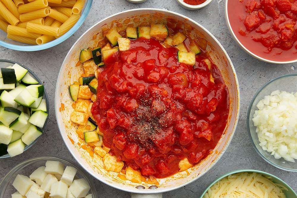 The halloumi pasta bake pan with a pinch of pepper and some chopped tomatoes.