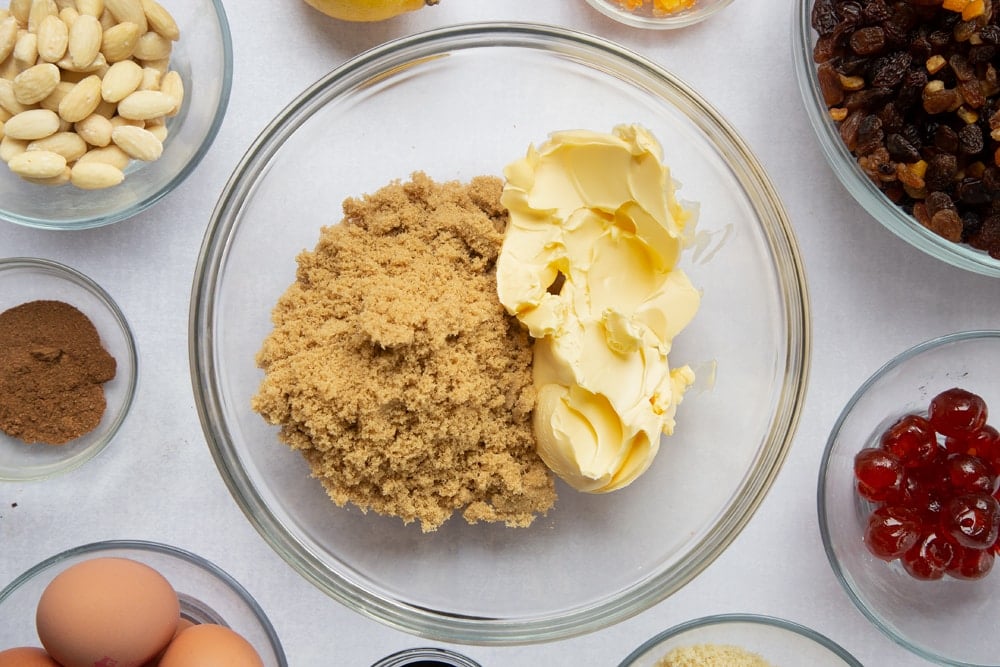 brown sugar and butter in a large clear bowl surrounded by ingredients in smaller clear bowls.