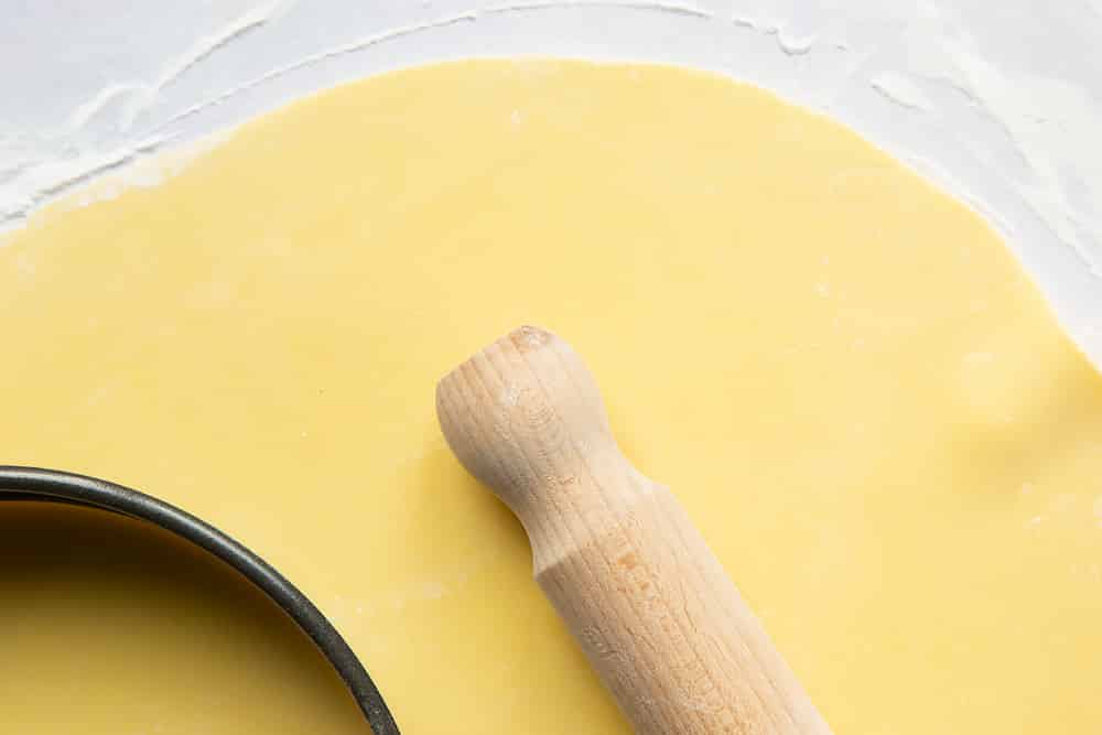 thin marzipan rolled out on a floured surface with a cutter and rolling pin.