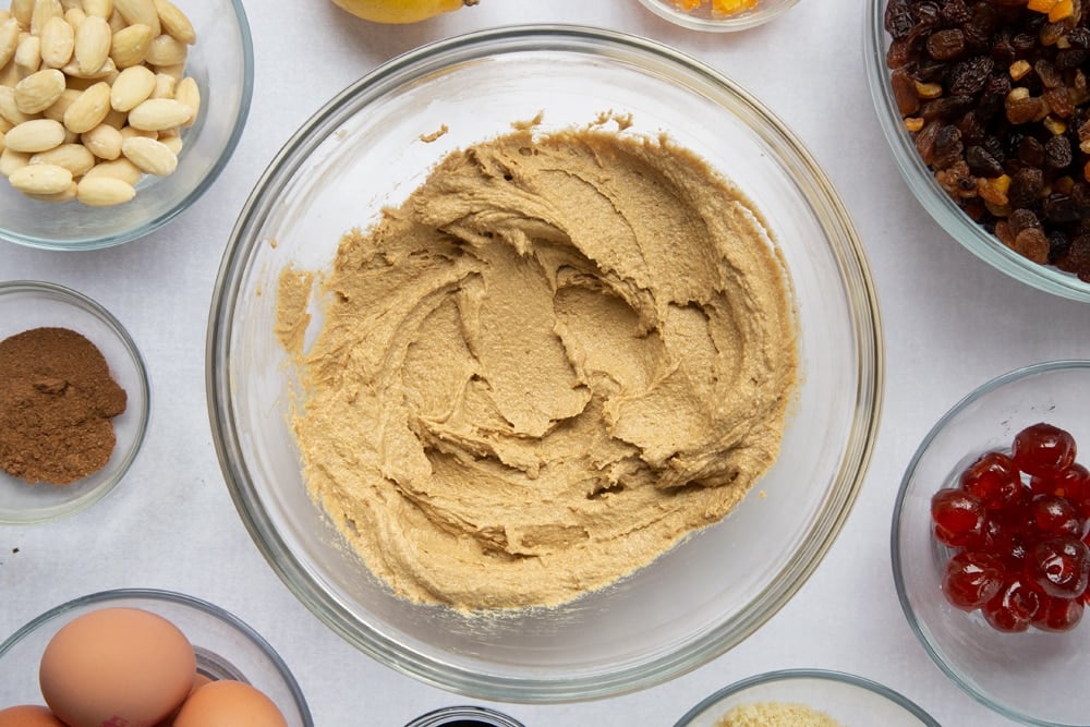 brown sugar and butter creamed together with treacle in a large clear bowl surrounded by ingredients in smaller clear bowls.