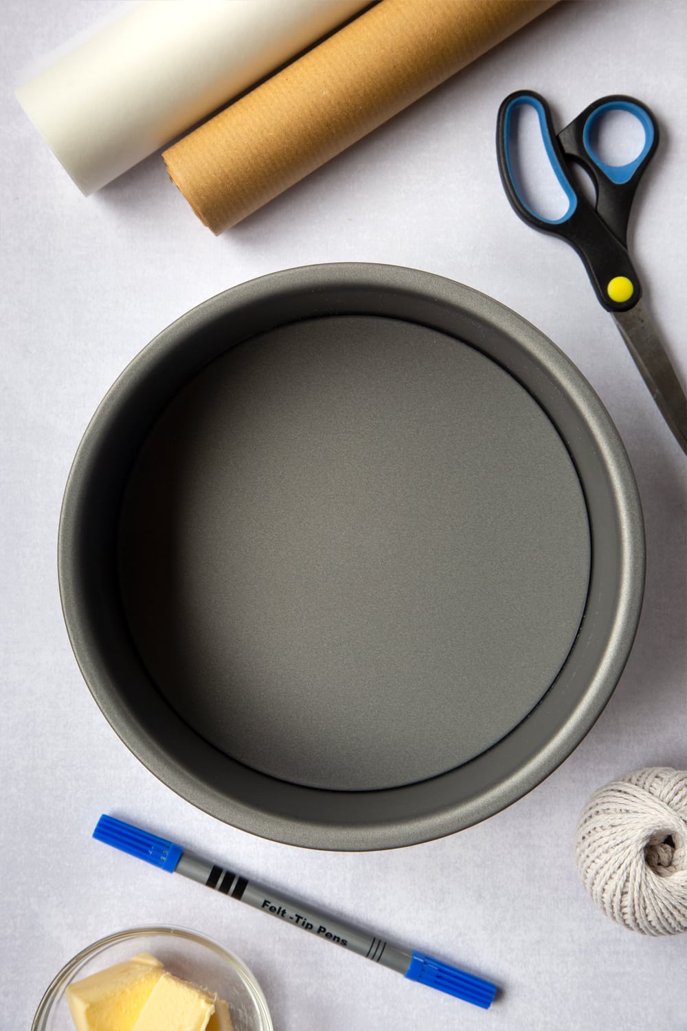 The materials you will need to complete this Idiot's guide to lining a Christmas cake tin. Baking paper, Brown paper, String (non-plastic)
A medium loose-bottomed cake tin, Butter (to grease), Scissors, Pen / pencil