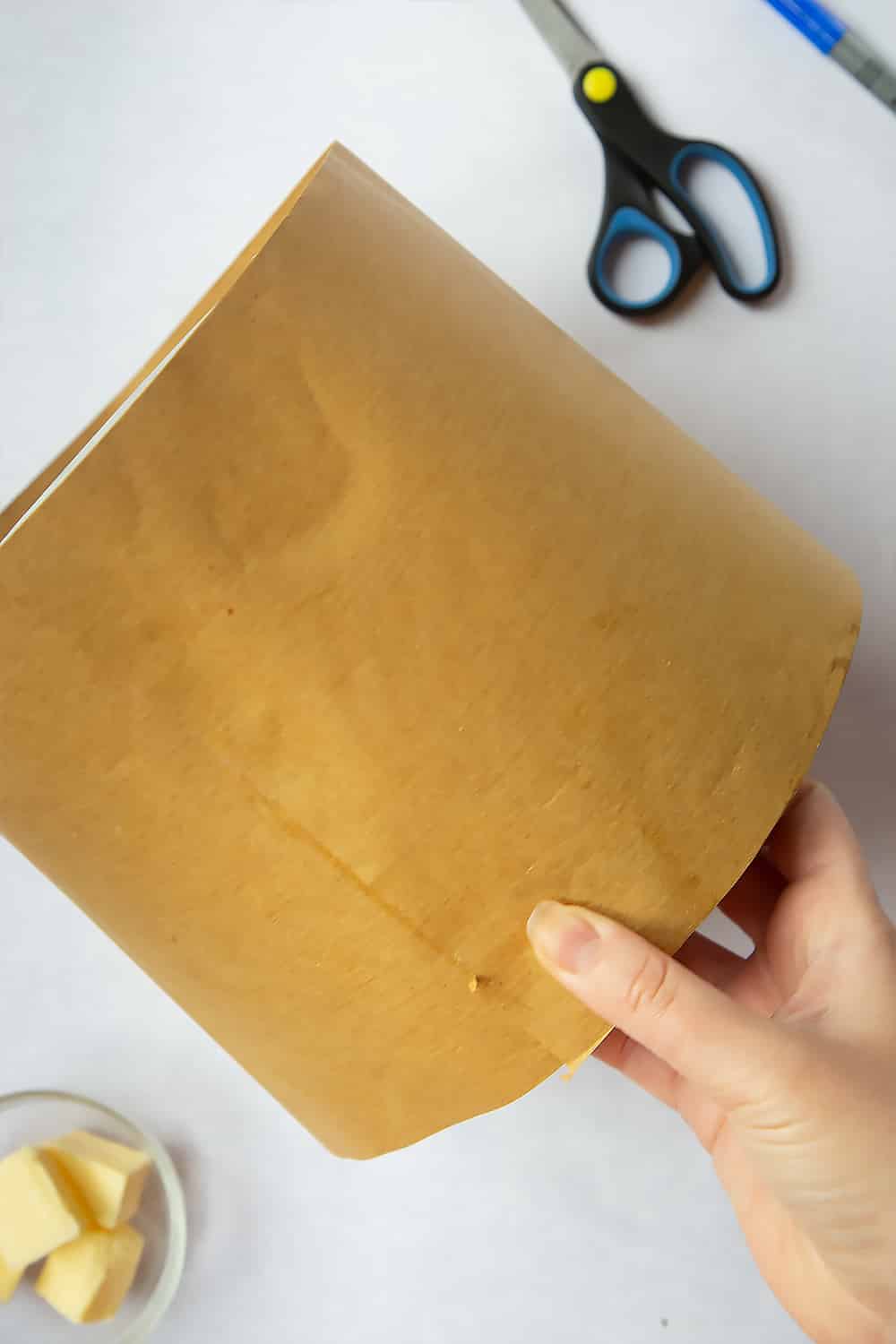 Wrapping the brown paper which has been cut to the outside of the baking tin. 