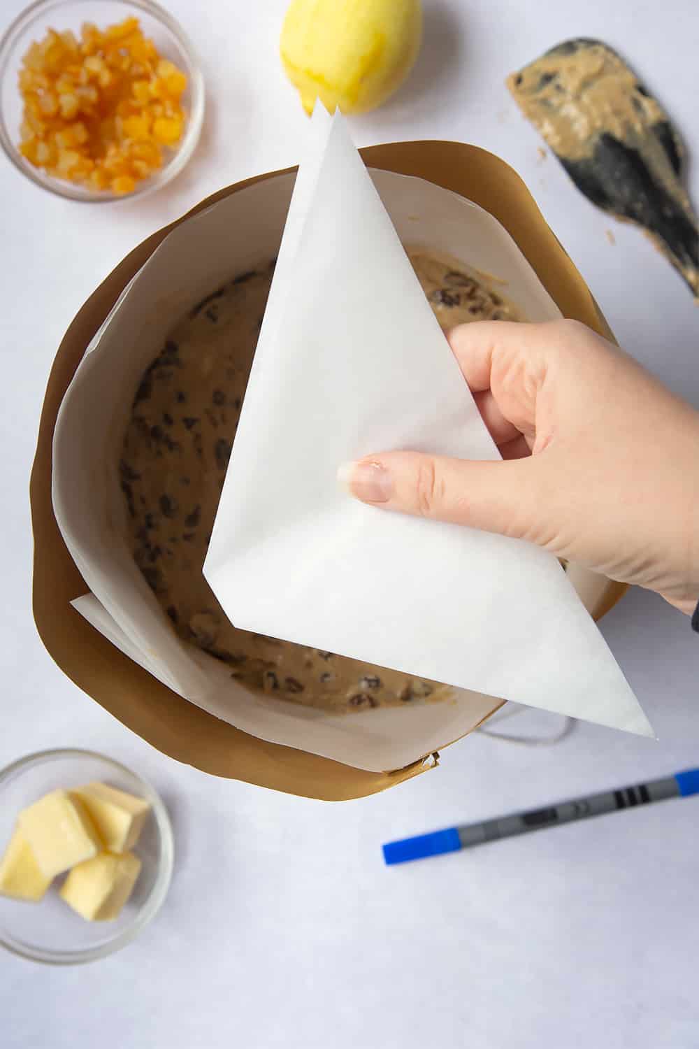 Baking paper that's been cut into a square slighlty bigger than the baking tin used in this Idiot's guide to lining a Christmas cake tin tutorial. Which has been folded into quarters and cut again at a 45 degree angle around 1cm in from the edge. 