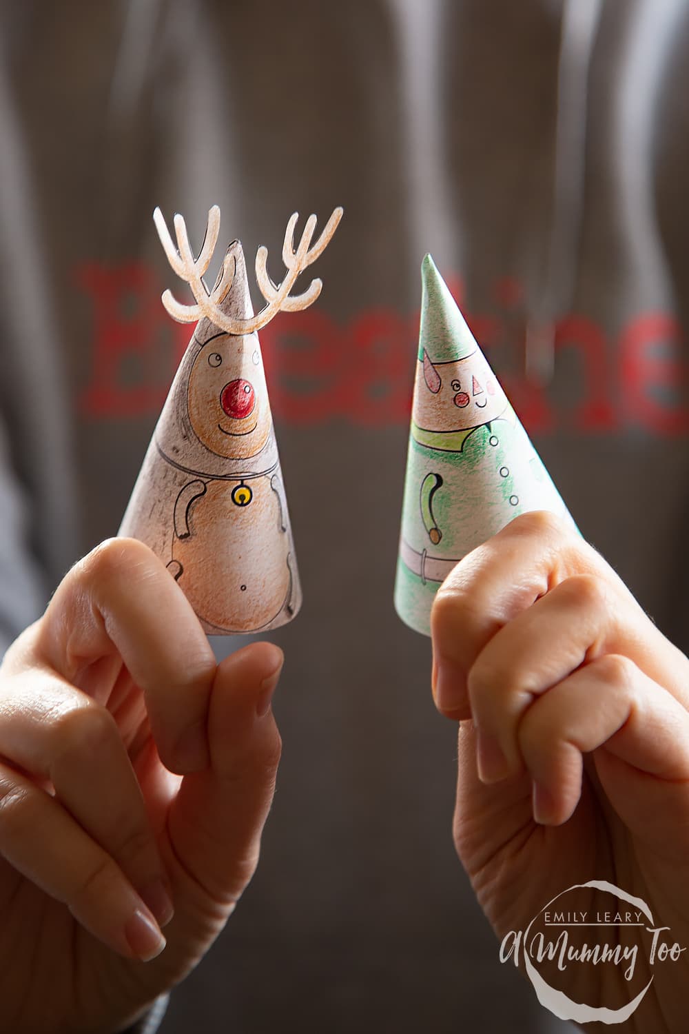 2 hands holding 2 3D christmas characters coloured in pencil.