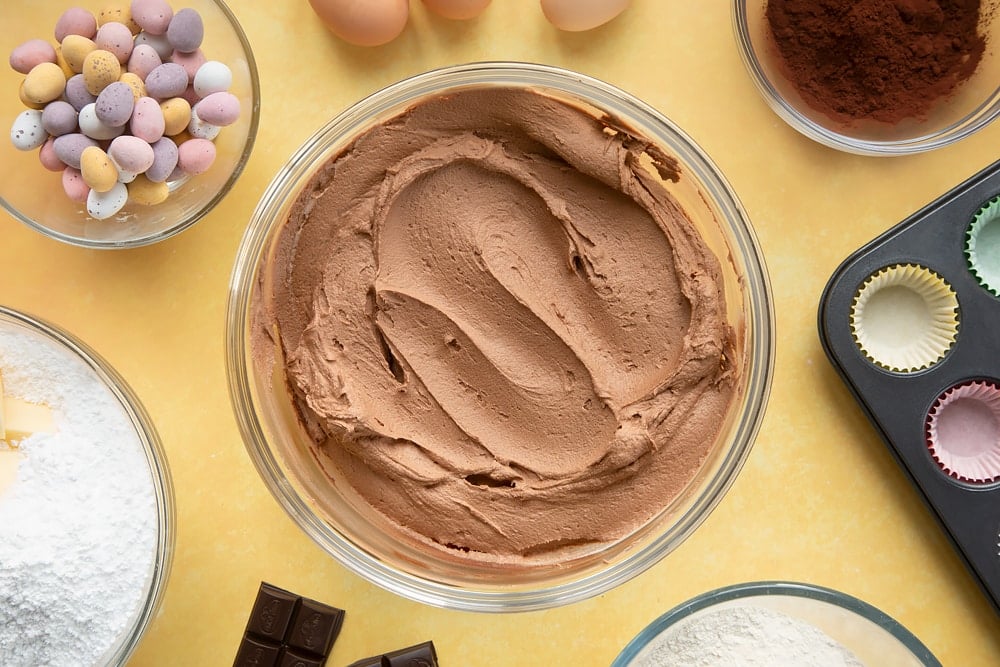 Overhead shot of chocolate frosting in a large clear bowl