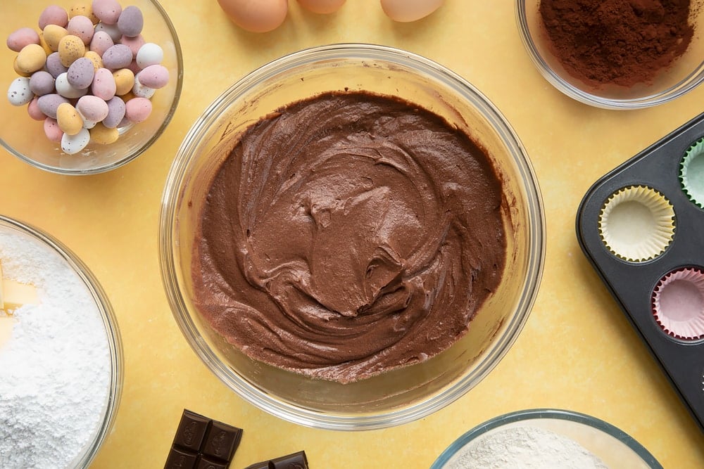 Overhead shot of chocolate muffin mix in a large clear bowl