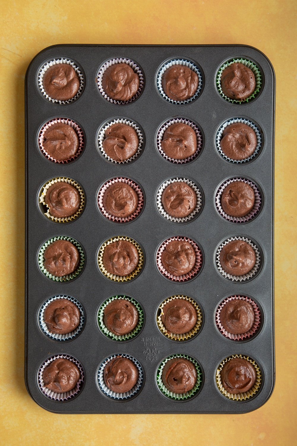 Overhead shot of chocolate muffin mix mini cupcake pan with mini cupcake cases