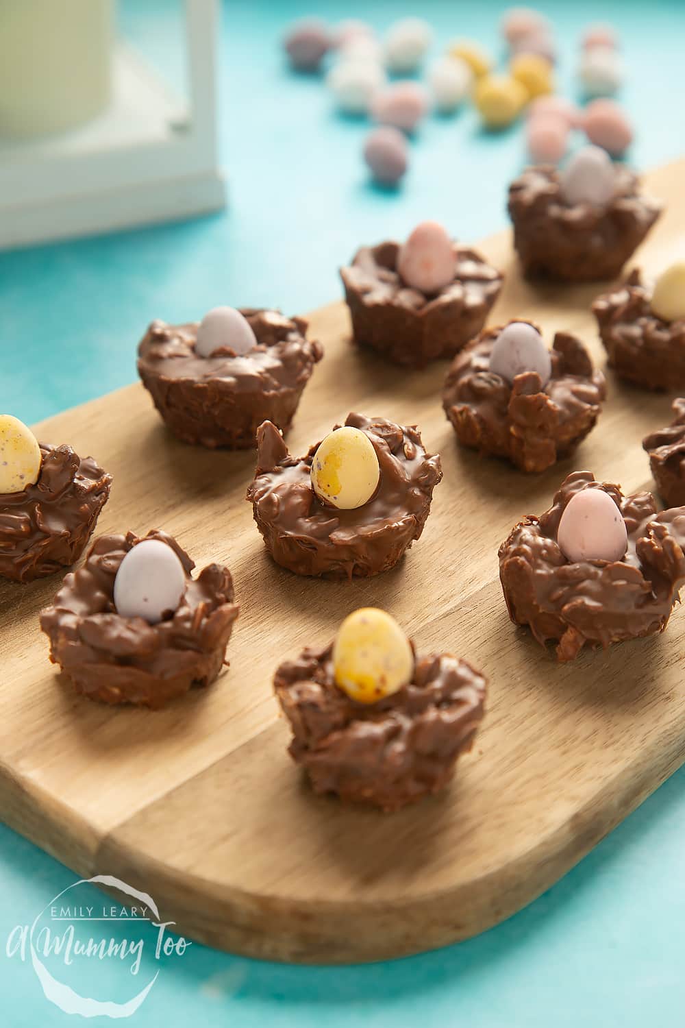 Front angle shot of Crunchy, chewy, fruity muesli chocolate Easter nests served on a wooden board with a mummy too logo in the lower-left corner