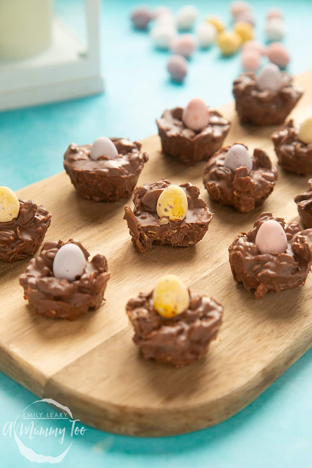 Front angle shot of Crunchy, chewy, fruity muesli chocolate Easter nests served on a wooden board with a mummy too logo in the lower-left corner