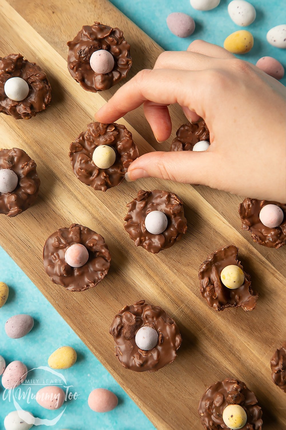  Overhead shot of a hand holding a chocolate Easter nest cakes with an Easter egg