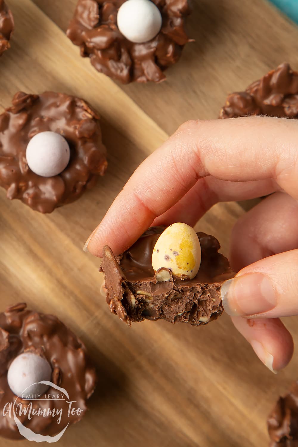 Overhead shot of a hand holding a chocolate Easter nest cakes with an Easter egg