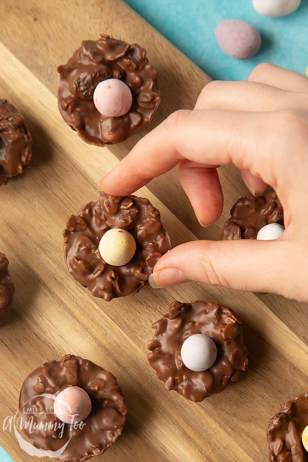 Overhead shot of a hand holding a fruity muesli chocolate Easter nest with a mummy too logo in the lower-left corner