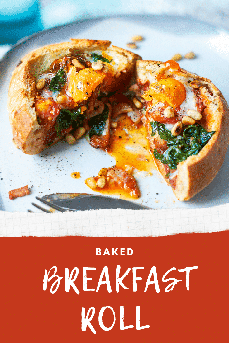 A breakfast roll on a white plate. It is filled with sausage, bacon, spinach, tomatoes and pine nuts, topped with an egg. The roll is cut open to reveal the runny egg yolk. The caption reads: Baked breakfast roll