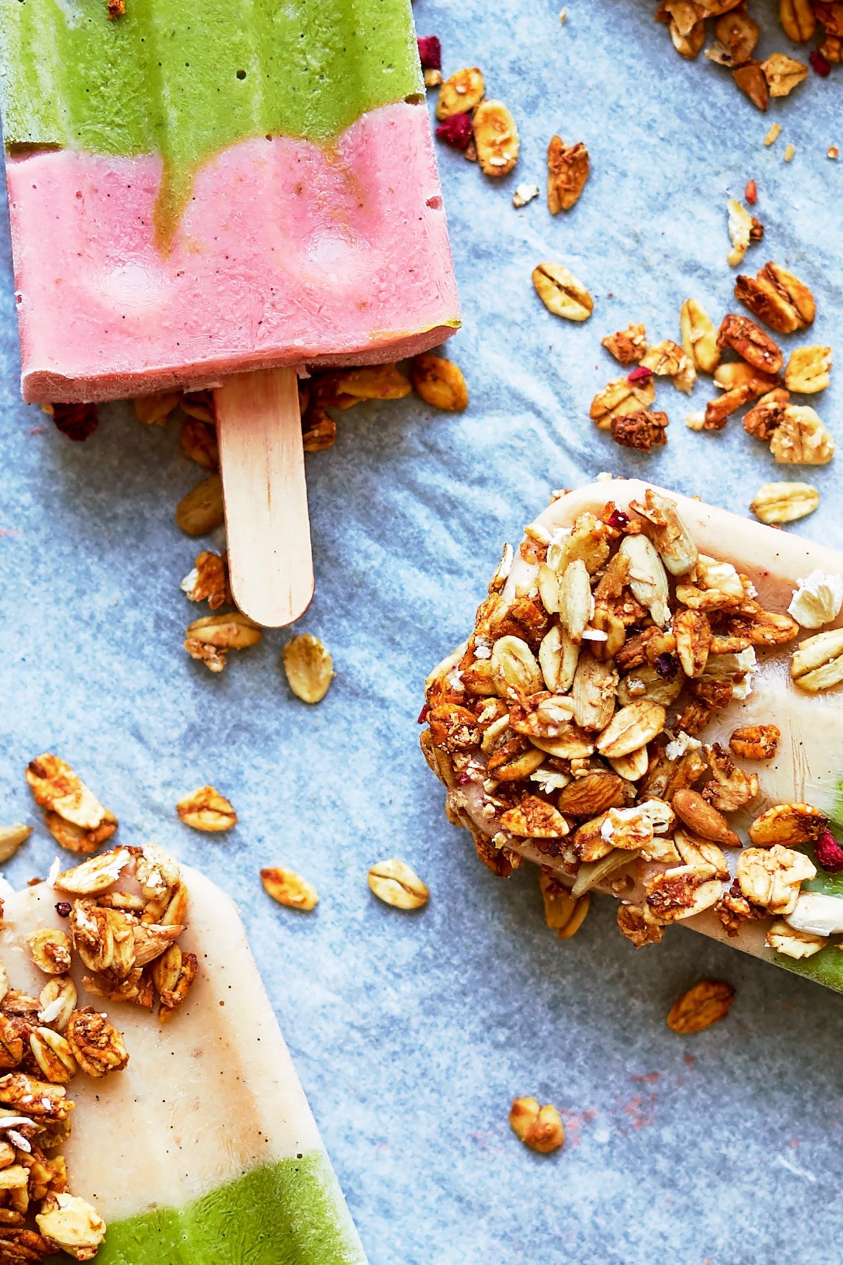 Close up showing the granola of a fruit and veg lollies on a granite board.