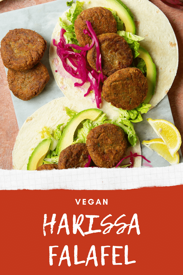 Two harissa falafel wraps arranged on a board with pickled cabbage and salad. The text caption reads, vegan harissa falafel.
