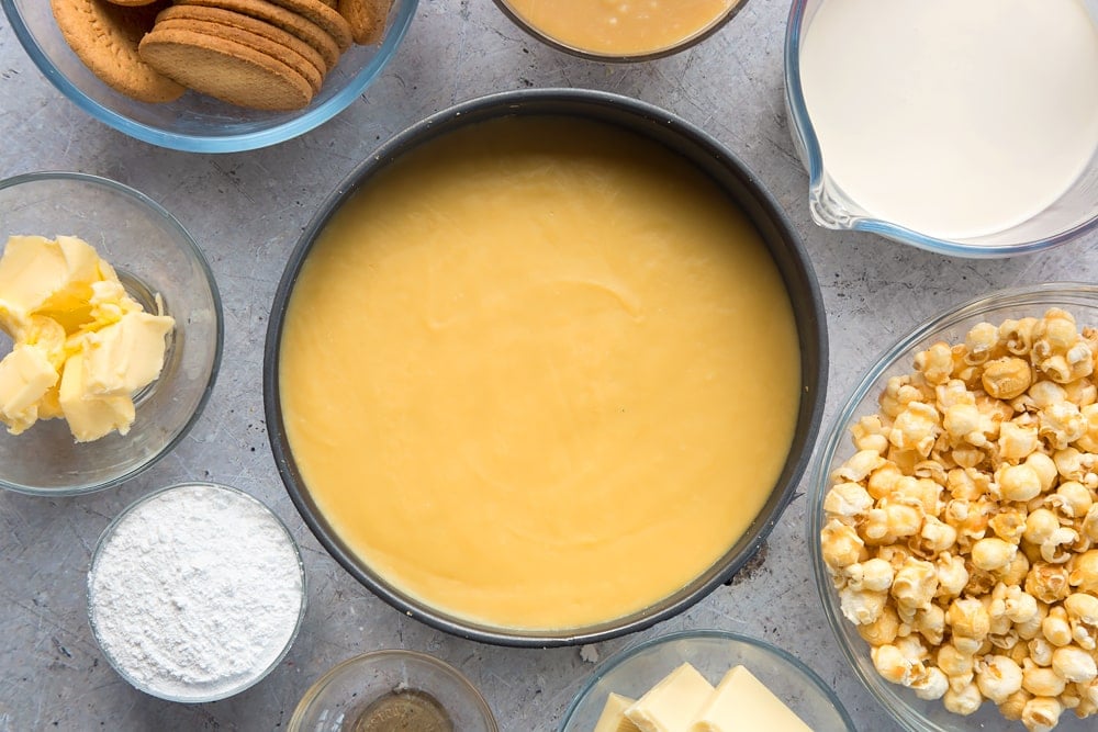 frozen cheesecake base topped with caramel in a cake tin.
