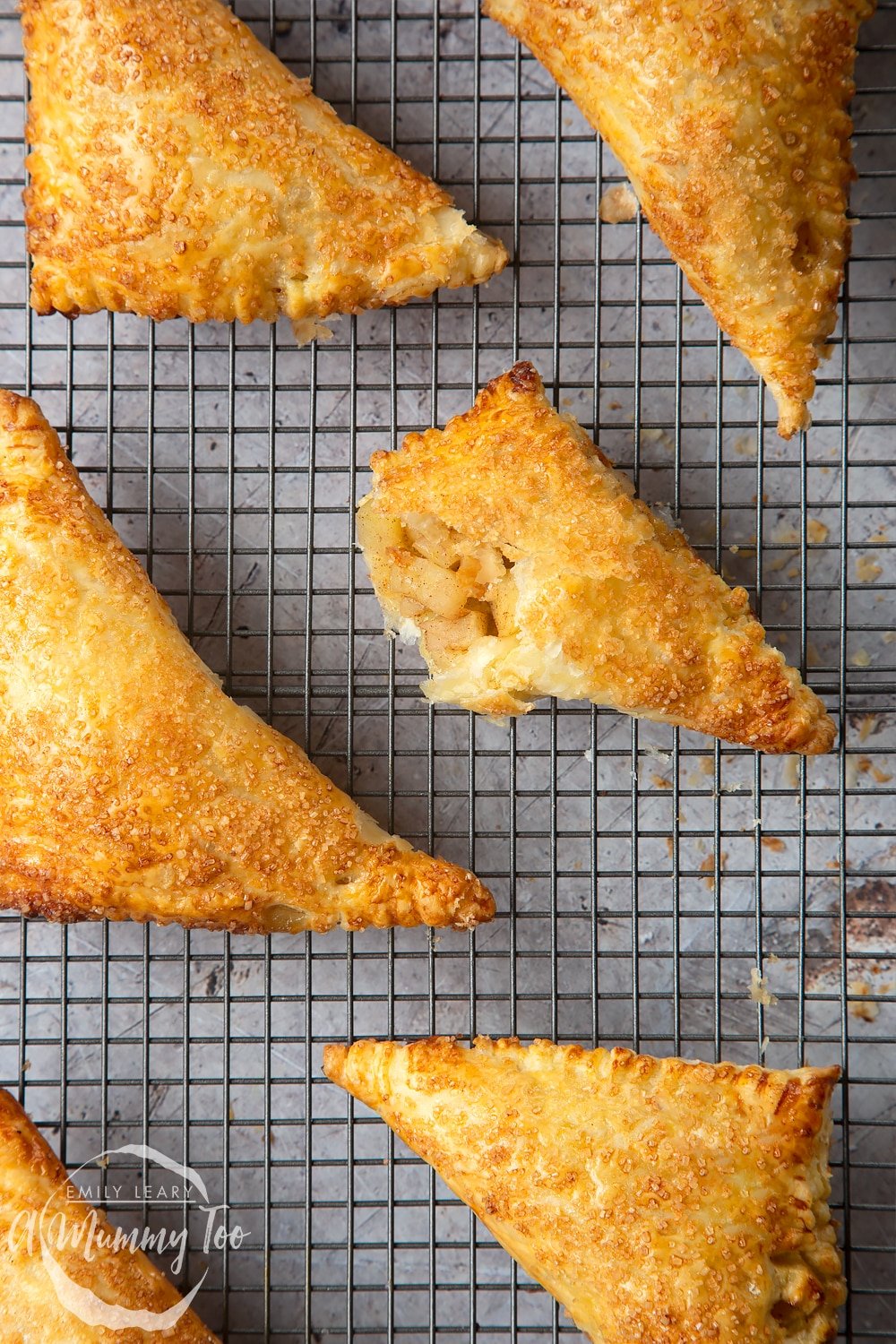 Overhead shot of a halved crispy Apple cinnamon turnover on a wire cooling wrack