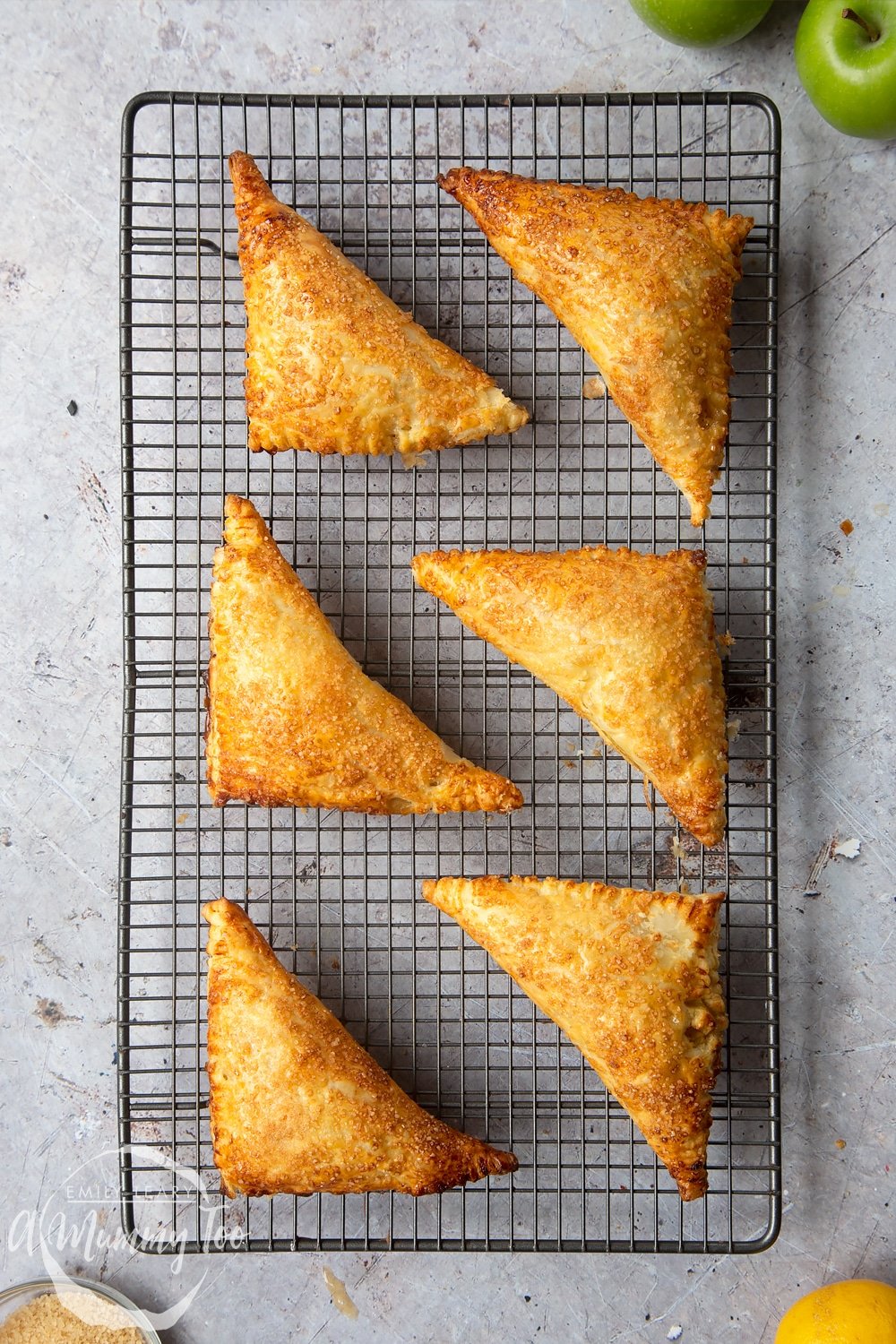 Overhead shot of the finished apple turnovers cooling on a wire rack.