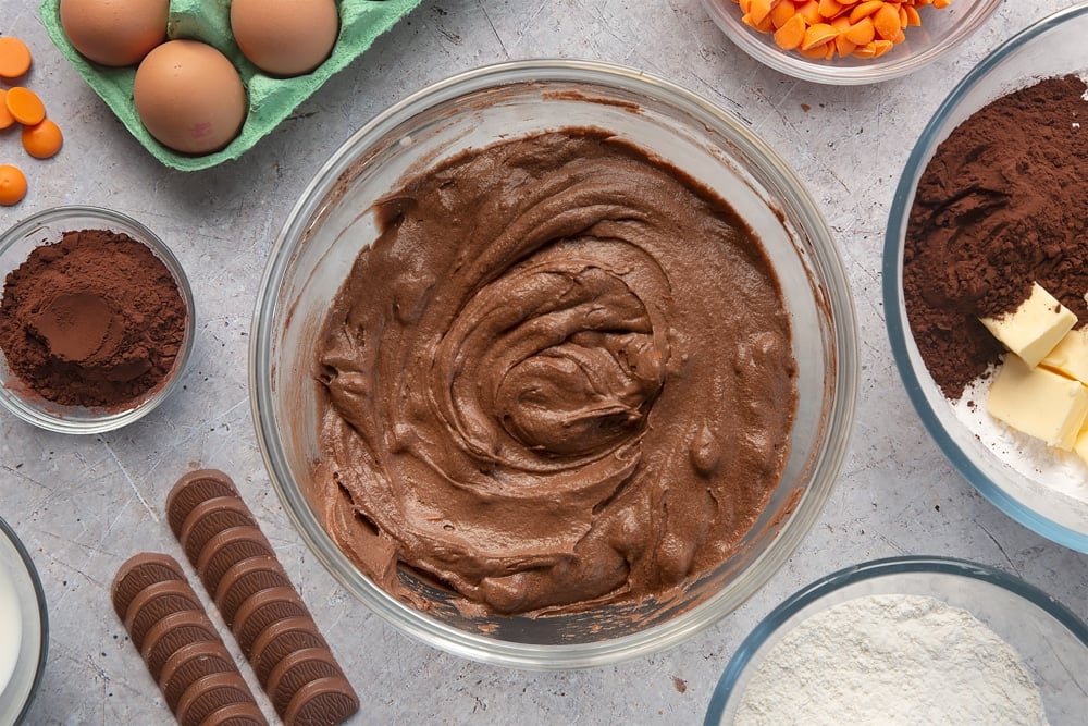Overhead shot of chocolate orange muffin batter in a large clear bowl