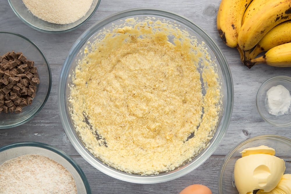 Overhead shot of mashed banana in a large clear bowl