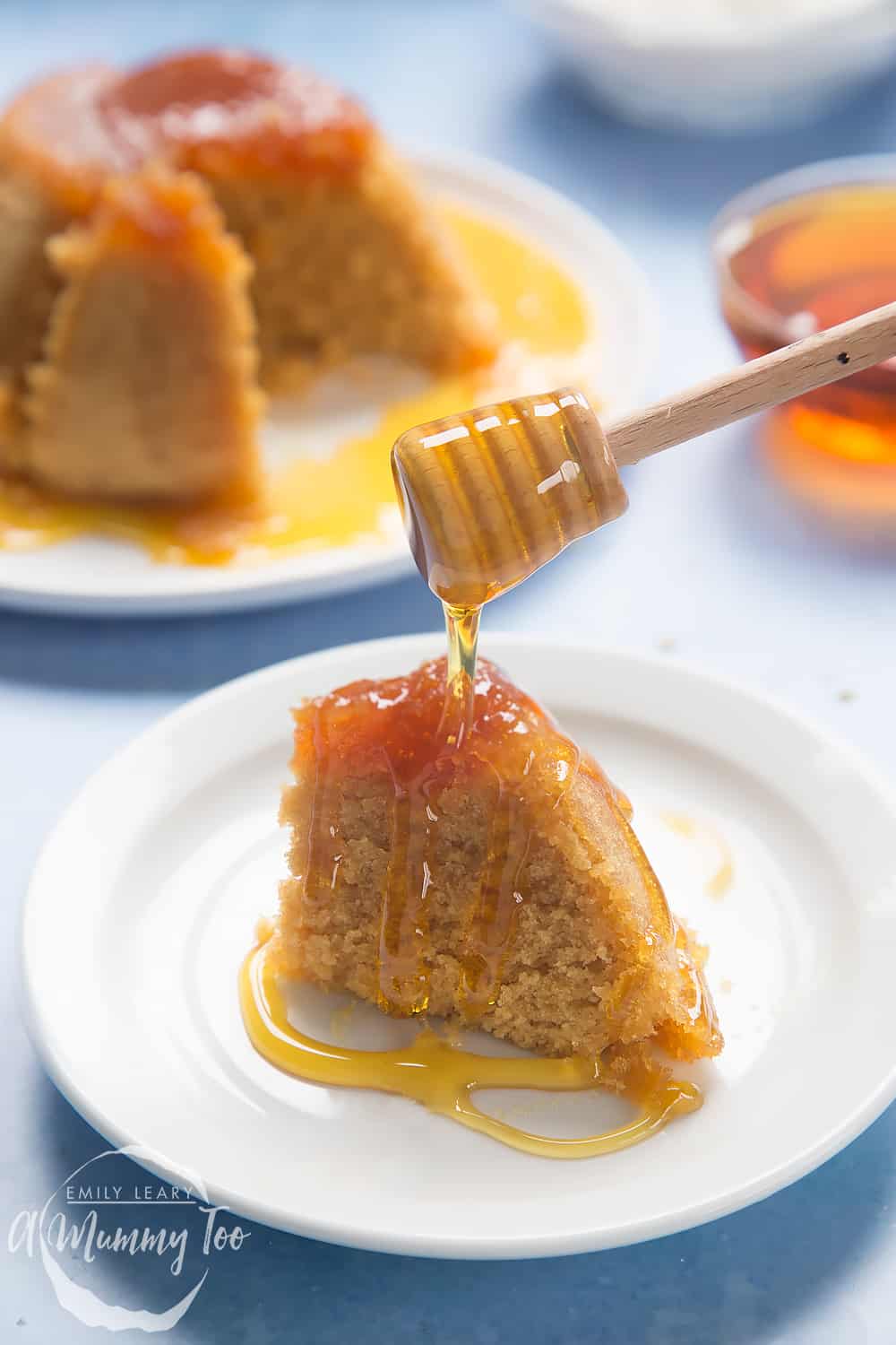 Front angle shot microwave syrup pudding served in a white plate with a mummy too logo in the lower-left corner