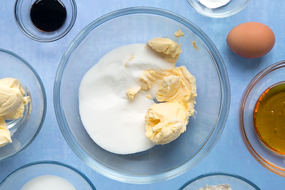 Overhead shot of sugar and butter in a large clear bowl