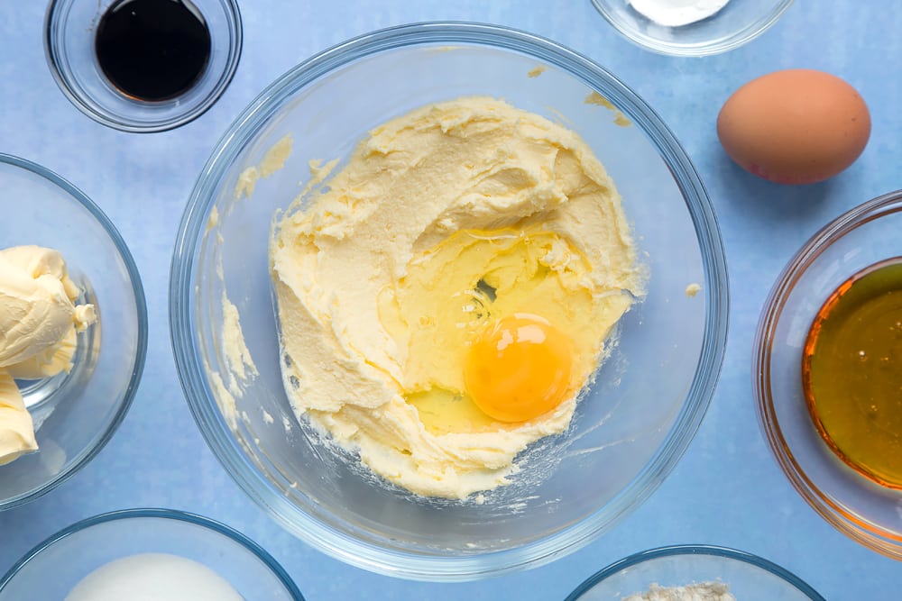 Overhead shot of sugar, butter and egg in a large clear bowl