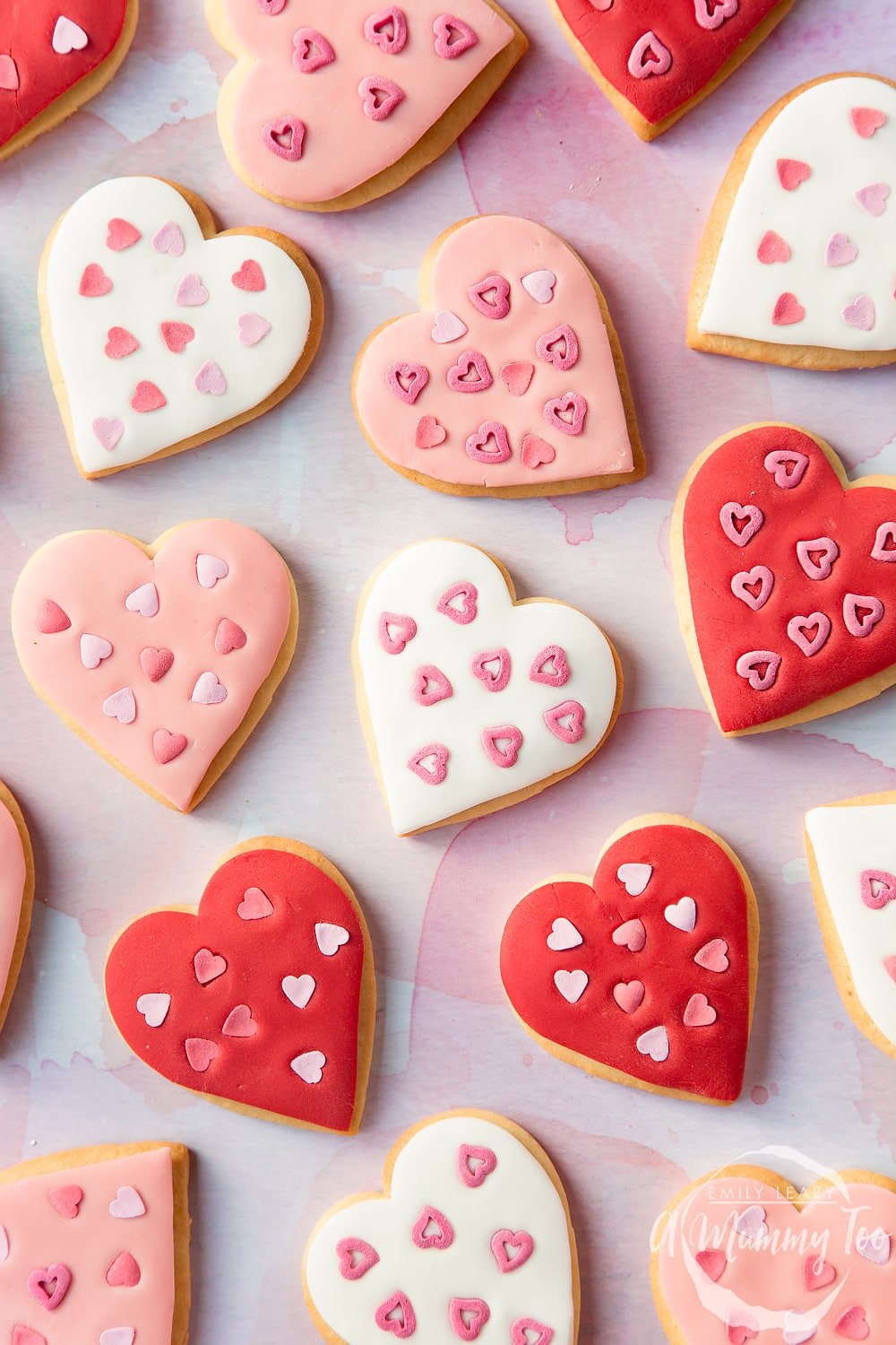 Overhead shot of valentines day cookies topped with fondant and heart shaped sprinkles