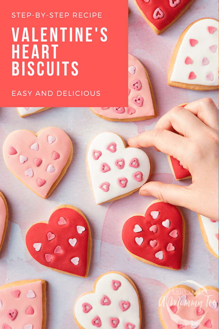 graphic text STEP-BY-STEP RECIPE VALENTINE'S HEART BISCUITS EASY AND DELICIOUS above Overhead shot of a hand touching a heart biscuit with a mummy too logo in the lower-right corner
