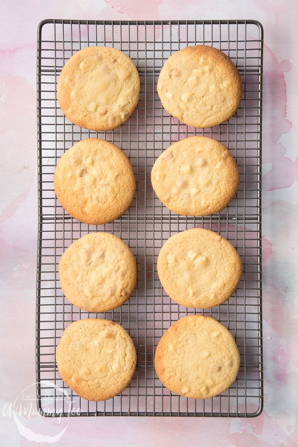 Overhead shot of four flattened cookie dough in a paper-lined baking sheet