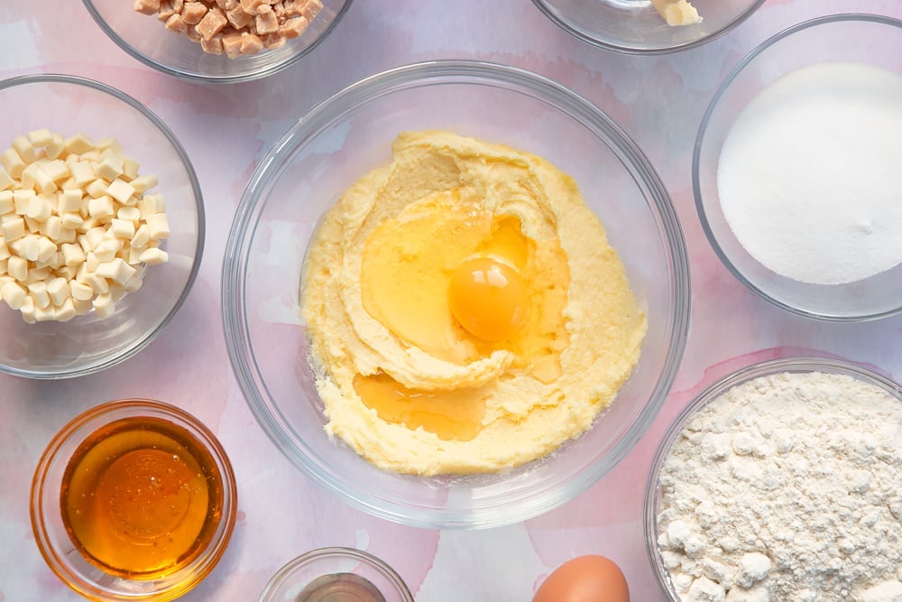 Overhead shot of margarine mix, vanilla and egg in a clear bowl