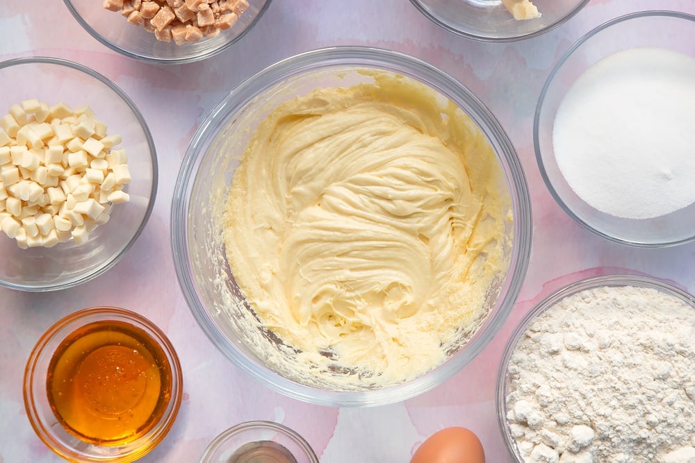 Overhead shot of margarine mix, vanilla and egg in a clear bowl