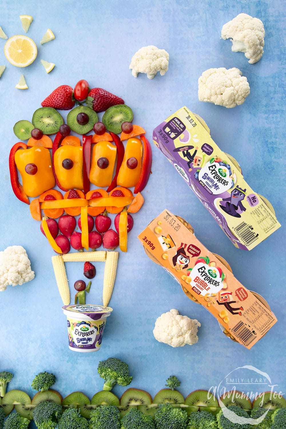 Overhead shot of a fruit flatlay with two three packs of the Arla Explorers yogurt. 