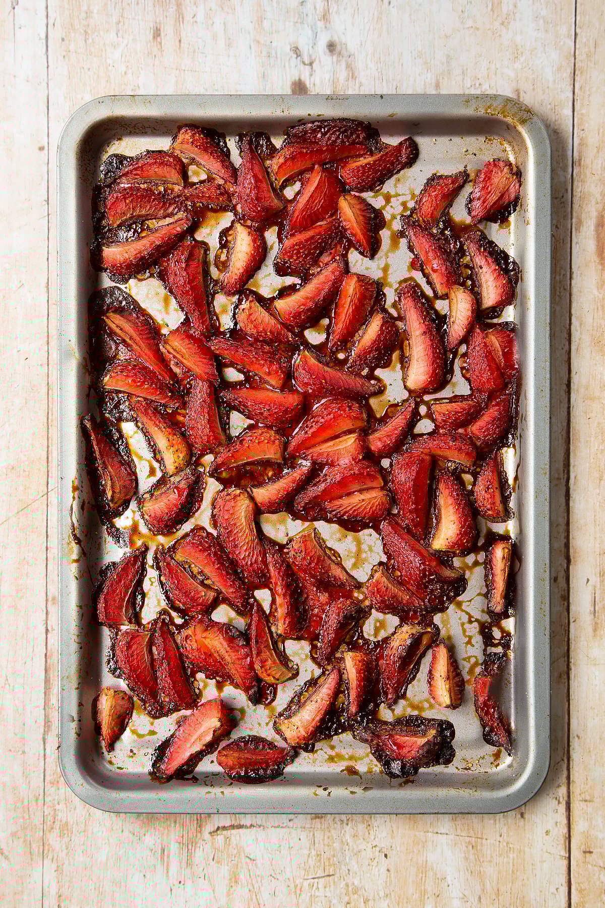 Roasted balsamic strawberries on a non-stick tray.